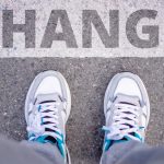 Close-up of sneakers on street with 'Change' text, symbolizing transformation.
